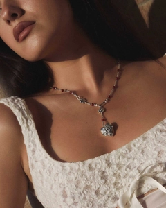 Détail du pendentif cœur vintage avec perles rouges et gravures ajourées précises