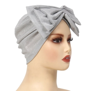 Detail of silver glitter turban hat featuring a large handmade bow decoration