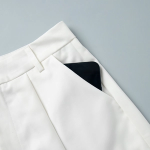 Detailed close-up of white high-waist suit shorts featuring deep side pockets for phone storage