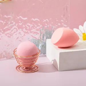 Close-up of pink makeup sponges and rose gold spiral holder on elegant display stands