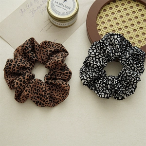 Detailed close-up of brown and black leopard print scrunchies in a lifestyle setting