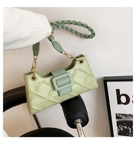 Close-up of mint green quilted baguette bag with geometric textured surface