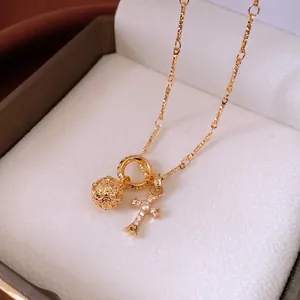 Vintage style gold necklace with hollow ball and shimmering cross pendant for women