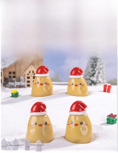 Miniature Christmas potato figurines with red hats set in a snowy micro landscape scene