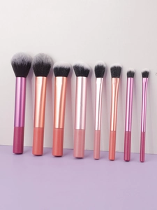 Gros plan sur 9 pinceaux de maquillage professionnels avec manches métalliques gradués