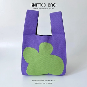 Detailed close-up showing the fine knitted texture and floral pattern of the purple tote bag