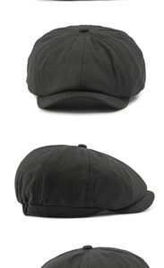 Dettaglio del cappello baker boy nero a spina di pesce con cuciture e bottone superiore