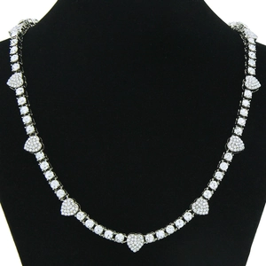 Detailed view of silver heart necklace with pave set white crystals on black mannequin