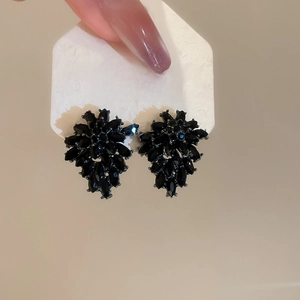Macro shot of black crystal flower earrings with S925 silver needle on a display card