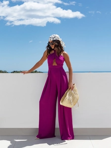 Detail of fuchsia halter jumpsuit featuring high waist cut and flowing wide leg trousers