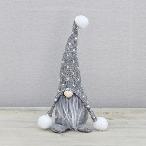 Gnome de Noël scandinave gris avec bonnet en tricot sur une surface en bois