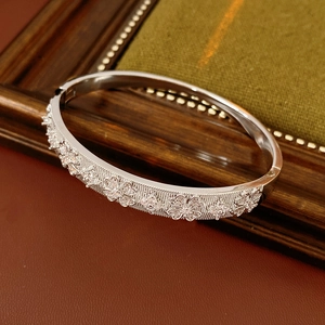 Close-up of silver zircon flower bangle with detailed gemstone pavé and clasp structure