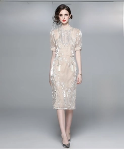 Detail of sequin pendant top and split skirt with intricate embroidery and white fringe