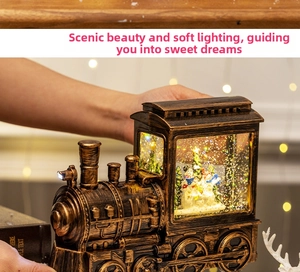 Close-up of vintage bronze Christmas train snow globe with glowing light and glitter