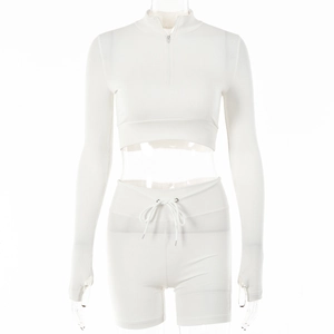 Close-up of white two-piece leisure set with zip-up cropped top and drawstring shorts