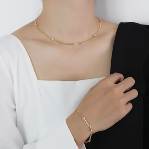 Gold plated snake chain jewelry set with green zircon stones on elegant model neck