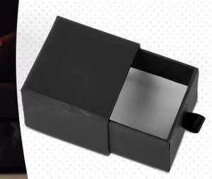 Close-up of elegant black drawer gift box with a ribbon handle for jewelry and dice sets