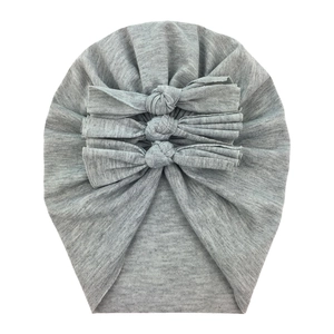 Detail of grey baby cotton beanie featuring three soft decorative bows on knit fabric