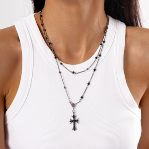 Close-up of gothic double-layer necklace with black rhinestone cross and vintage beads