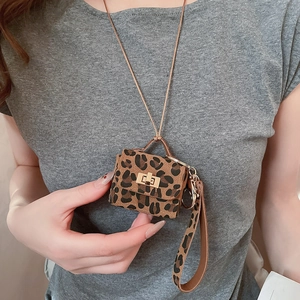 Detail of leopard print leather mini pouch with golden twist lock and neck strap
