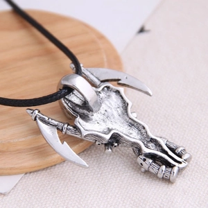 Vintage silver skull and axe pendant necklace with black cord on wooden background