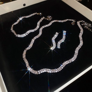 Detailed set of silver twisted wavy necklace, bracelet and earrings with sparkling rhinestones