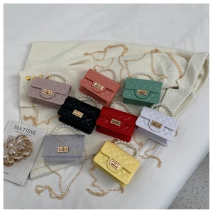 Detail of mini quilted jelly bags with pearl handles and gold chains in eight vibrant colors