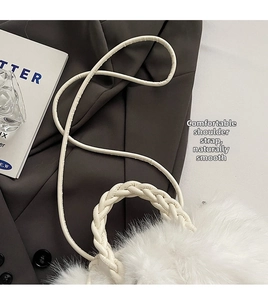 Detail of white plush shoulder bag with woven handle and leather strap on suit background