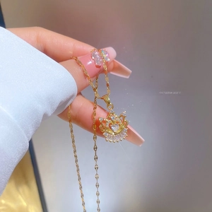 Macro shot of a luxury gold heart crown pendant necklace with micro-pave zircons