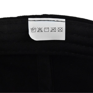 Detailed close-up of 100% cotton material washing label and textile care icons on the cap
