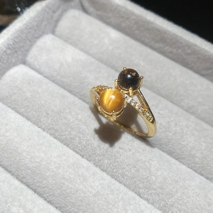 Detailed macro of gold plated tiger eye ring with cubic zirconia stones in a jewelry box