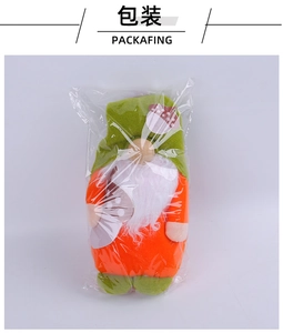 Christmas gnome plush in festive orange and green colors shown in clear plastic packaging