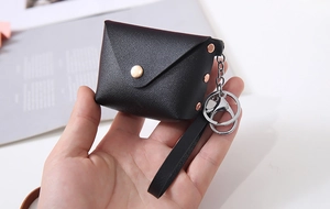 Detailed view of black PU leather mini pouch with pebble texture and gold metal buckle