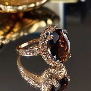 Macro view of vintage rose gold ring with large oval brown stone and hollow carving