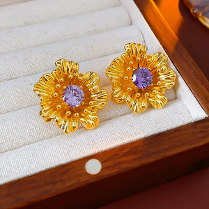 Detail of vintage flower stud earrings with purple zircon in a luxury wooden box
