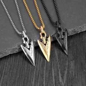 Arrowhead pendant necklaces in silver, gold, and black finishes on a textured stone plate