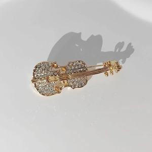 Detailed macro view of violin brooch with sparkling rhinestones and gold plating