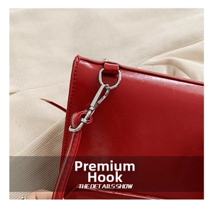 Detailed macro view of high-quality silver metal hook on a red leather backpack strap