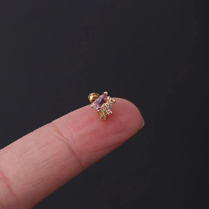 Detailed close-up of a mini heart-shaped gold stud earring with pink tourmaline zircon