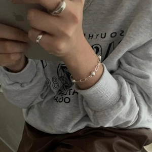 Minimalist 925 sterling silver beaded bracelet and simple silver rings worn by a model