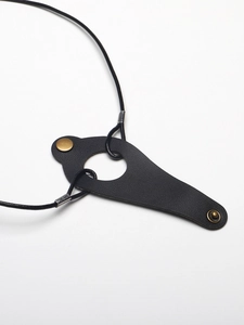Detail of black leather glasses strap featuring vintage bronze metal snap button closure