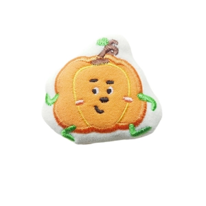 Cute cartoon pumpkin plush patch with green leaf on clean white background