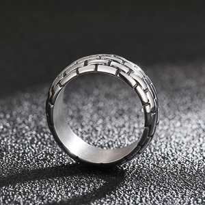 Macro detail of industrial style square ring with textured brick pattern in silver steel