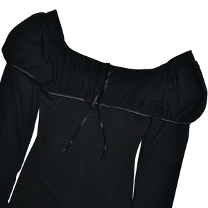 Détail d'une robe avec col carré, manches bouffantes et plis avec décoration de nœud