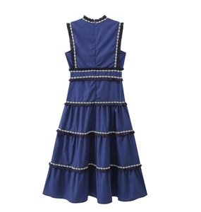 Détail de la robe sans manches bleu foncé avec jupe à volants et bordures à franges
