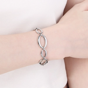 Close-up of geometric oval link stainless steel bracelet on wrist with polished finish