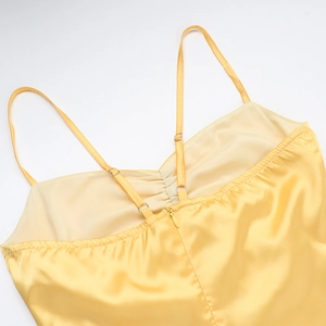 Detailed back view of yellow satin dress featuring slim straps and invisible zipper closure