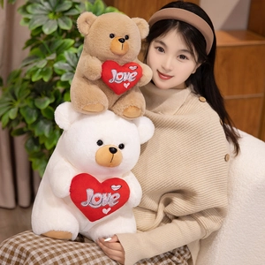 Brown and white teddy bears holding red Love hearts in a cozy indoor setting
