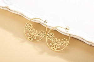 Detailed macro view of gold-tone hollow hoop earrings with three sunflower charms