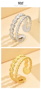Detail of double-row hammered metal rings in gold and silver finish with open band